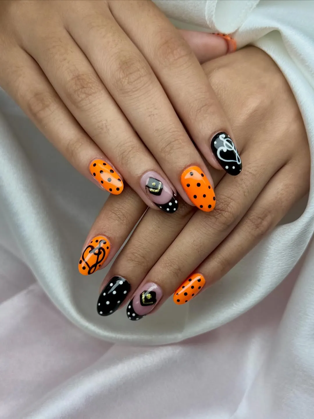 Orange and black polka dots with nude accent nails