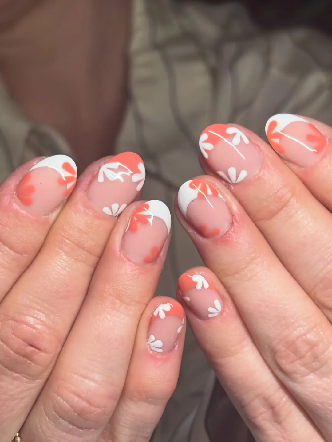 Orange French tips with small white petal motifs