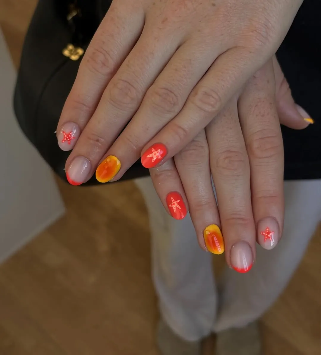Orange tips and gradient nails with starfish-like accents