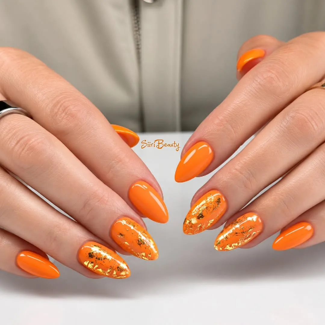 Bright orange almond nails with gold foil accents