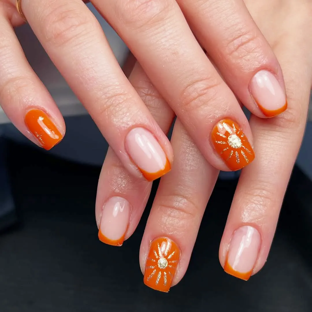 Orange French tips with daisy-like flower accents