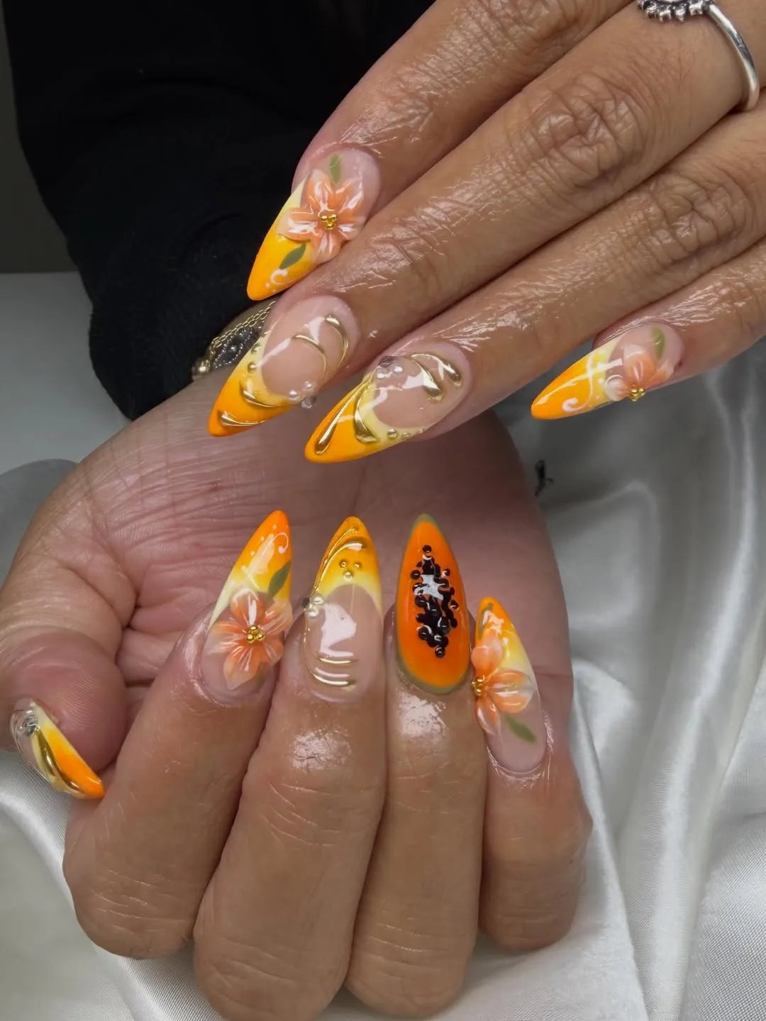 Ornate orange French tips with 3D flowers and bead accents