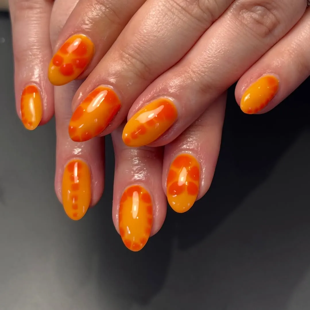Glossy orange-yellow marbled almond nails