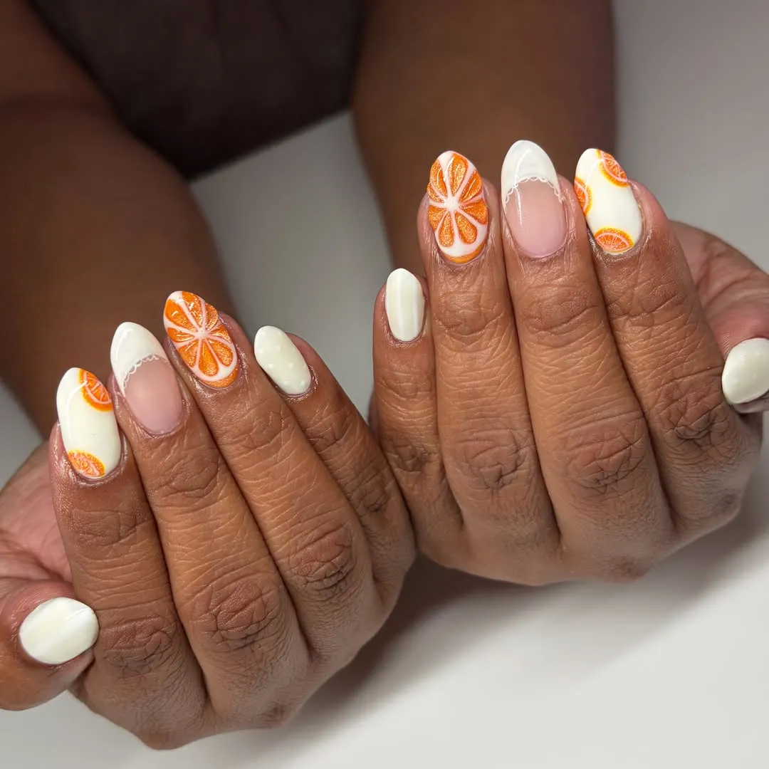 Orange-slice nail art with white accents