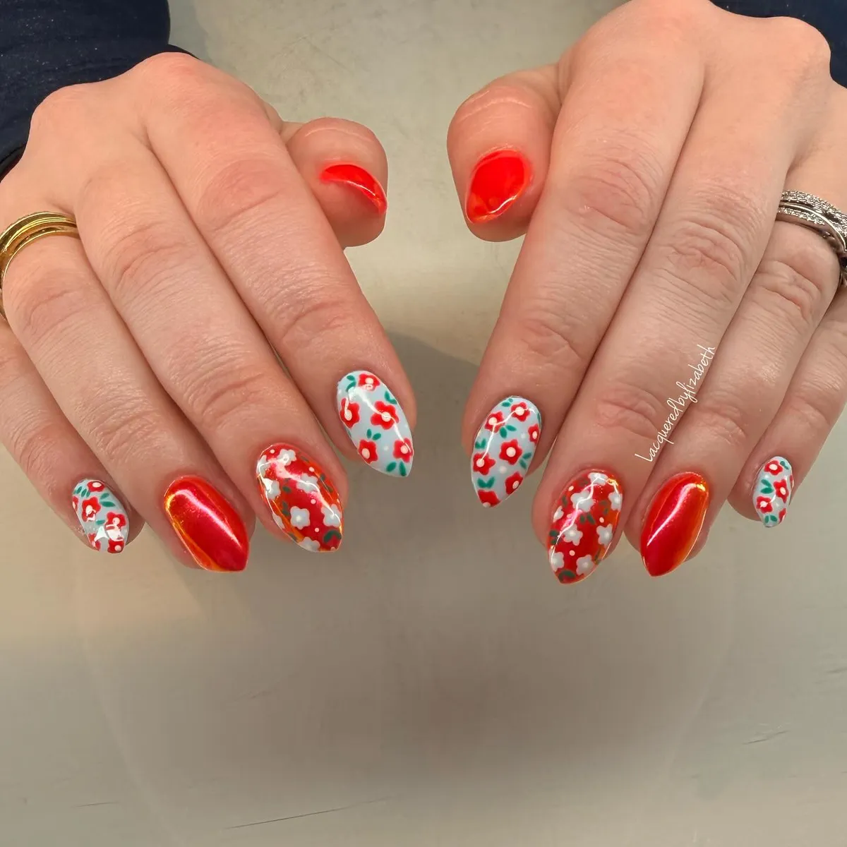 Metallic red-orange accents with white floral print nails