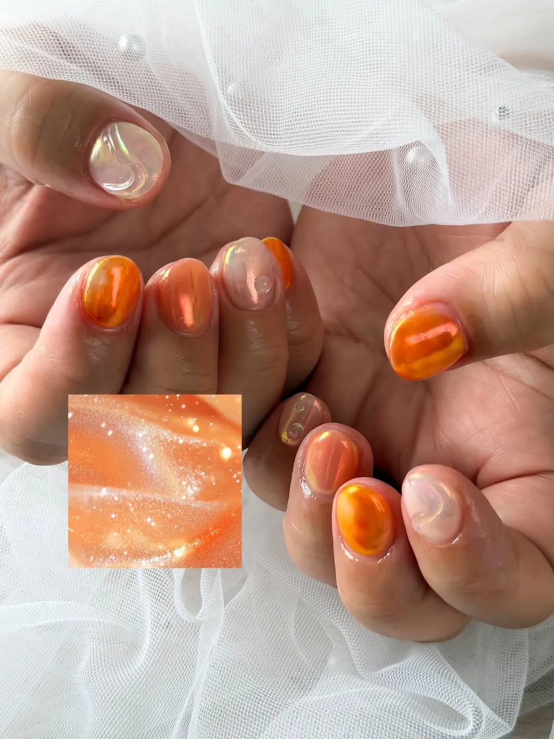 Short glossy orange reflective nails with sheer accents