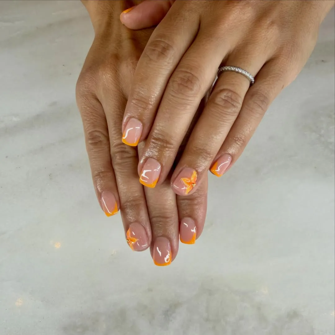 Thin Orange French Tips with a Minimal Floral Accent