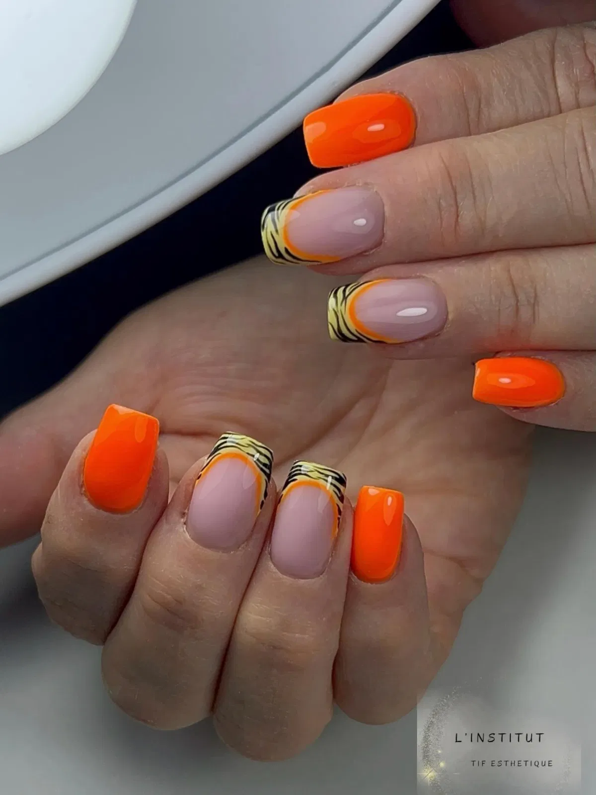 Bright Orange Nails with Striped French Tip Accents