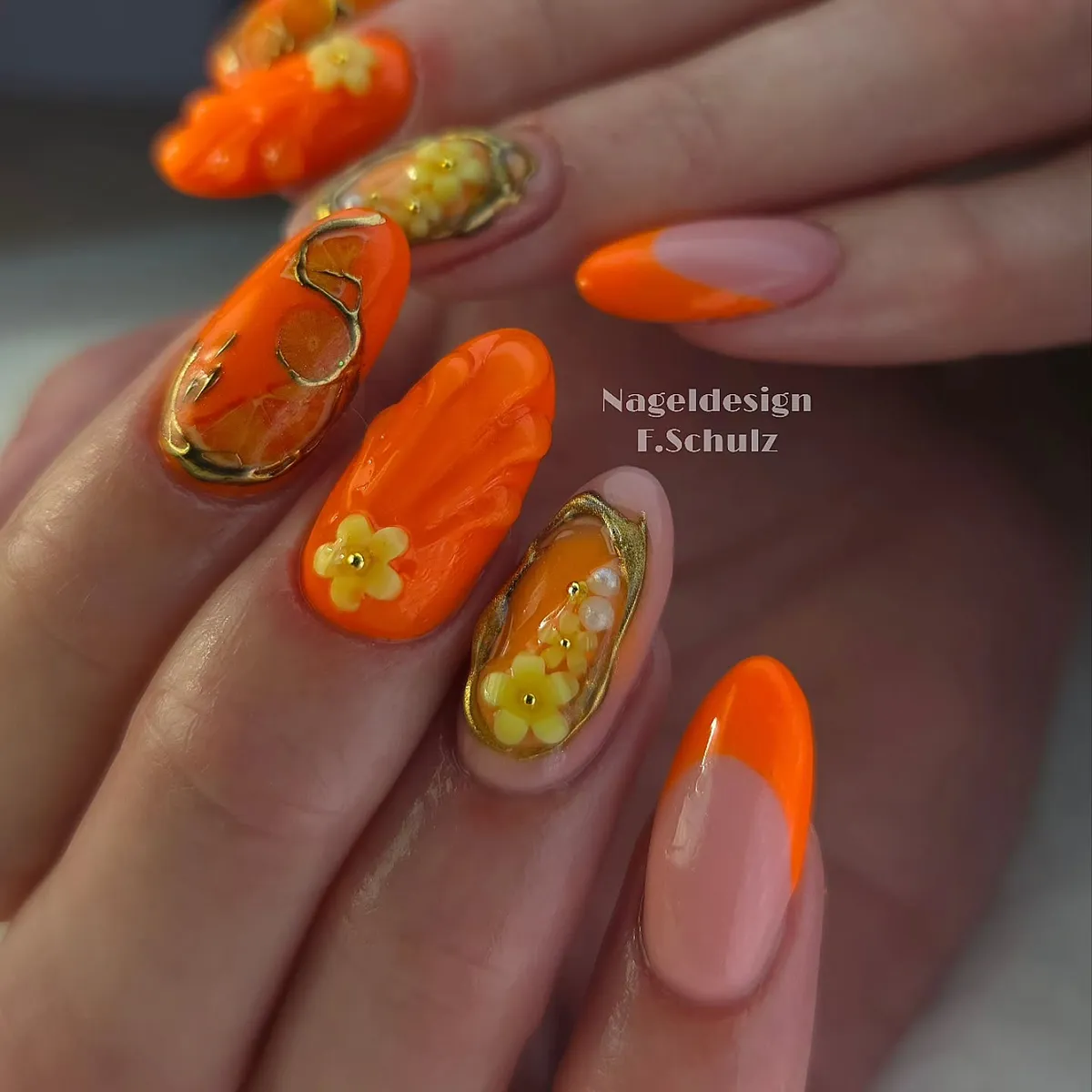 Orange French tips with raised yellow flowers and gold outlining
