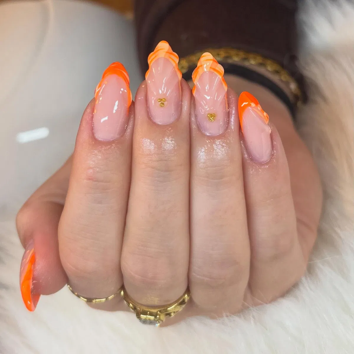 Orange French tips with raised waves and gold heart studs