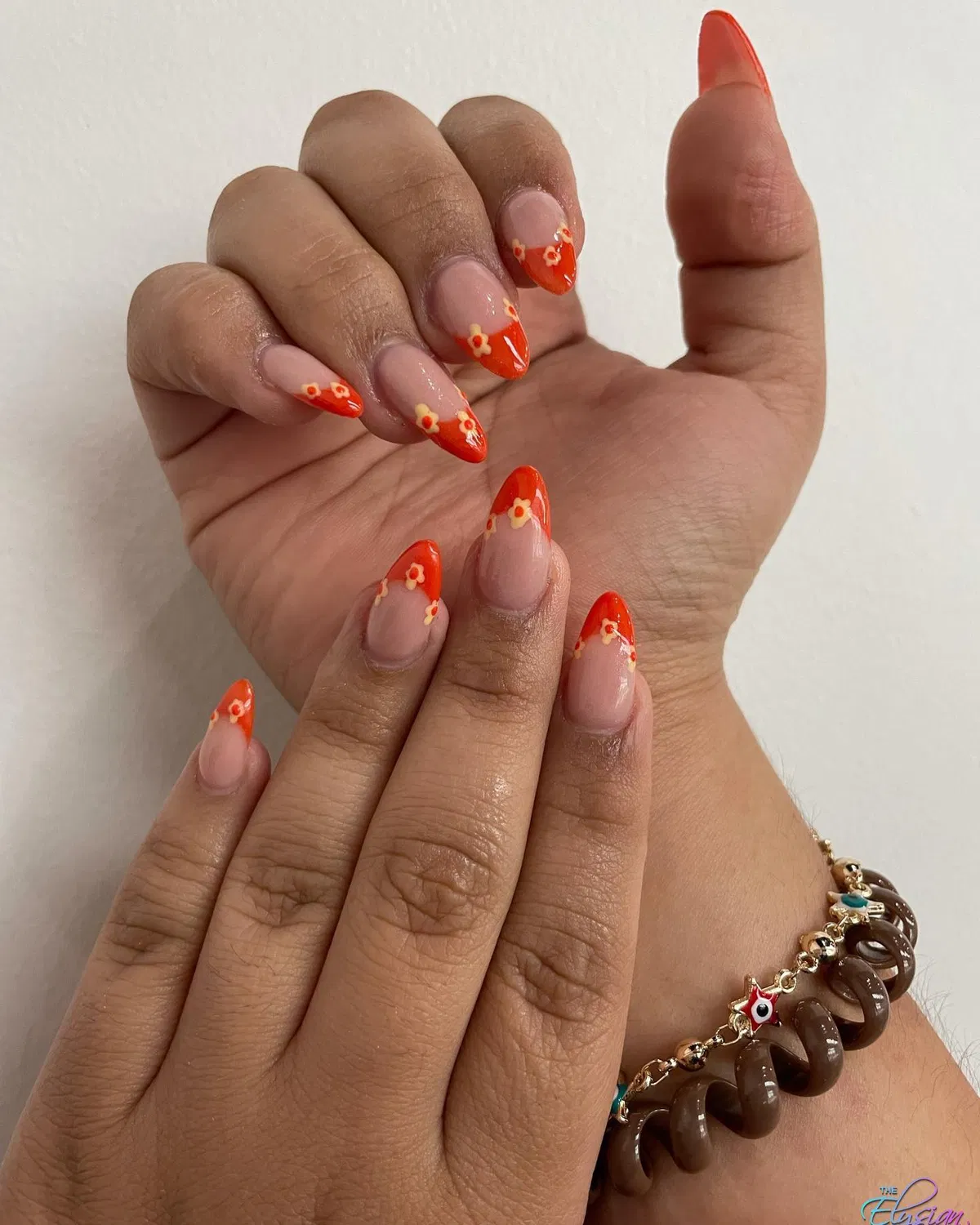 Orange French tips with tiny flower accents