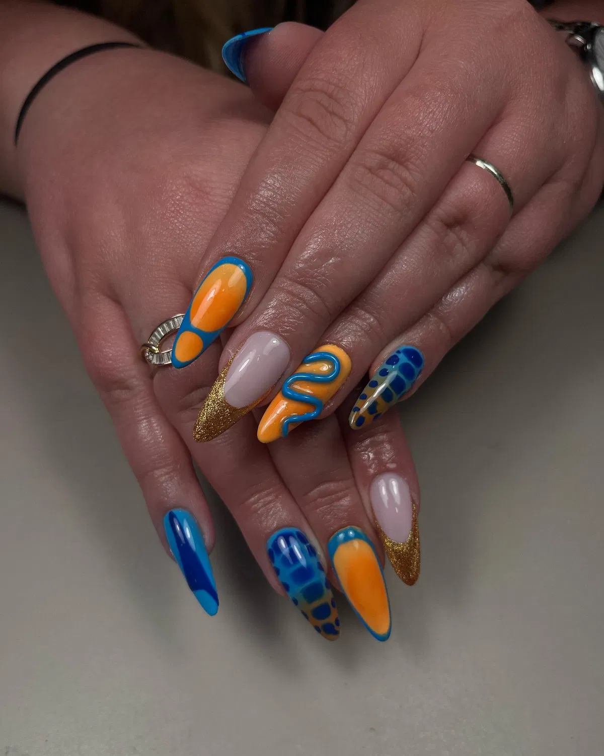 Orange and Blue Graphic Nails with Gold Glitter Tips
