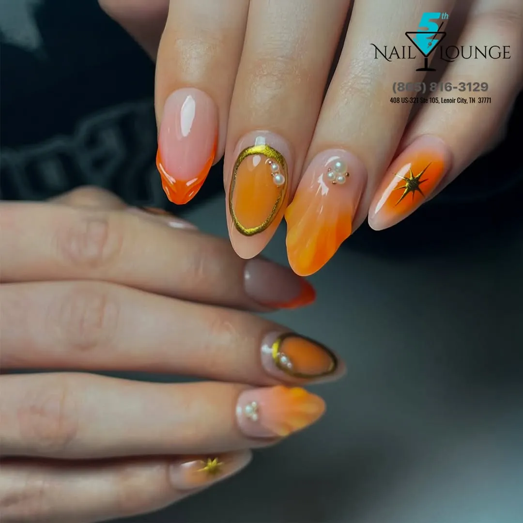 Orange ombrΓ© almonds with gold outline, pearls, and starburst accent
