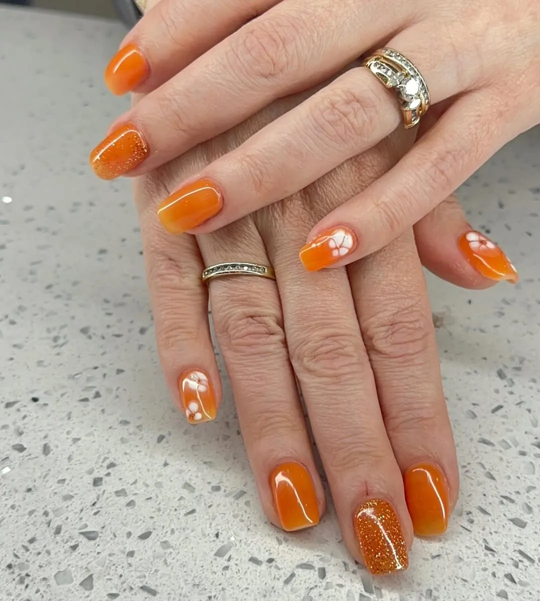 Glossy orange squares with glitter and white floral accents