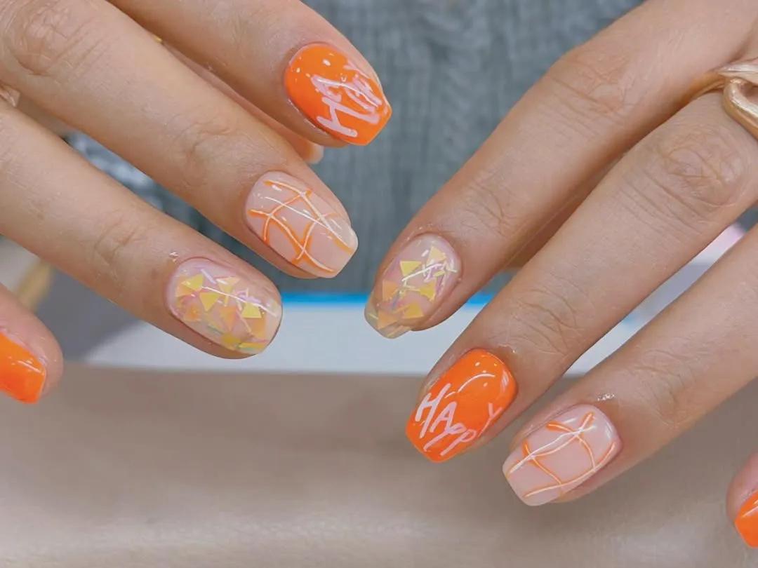 Short orange set with line art, iridescent triangles, and white script