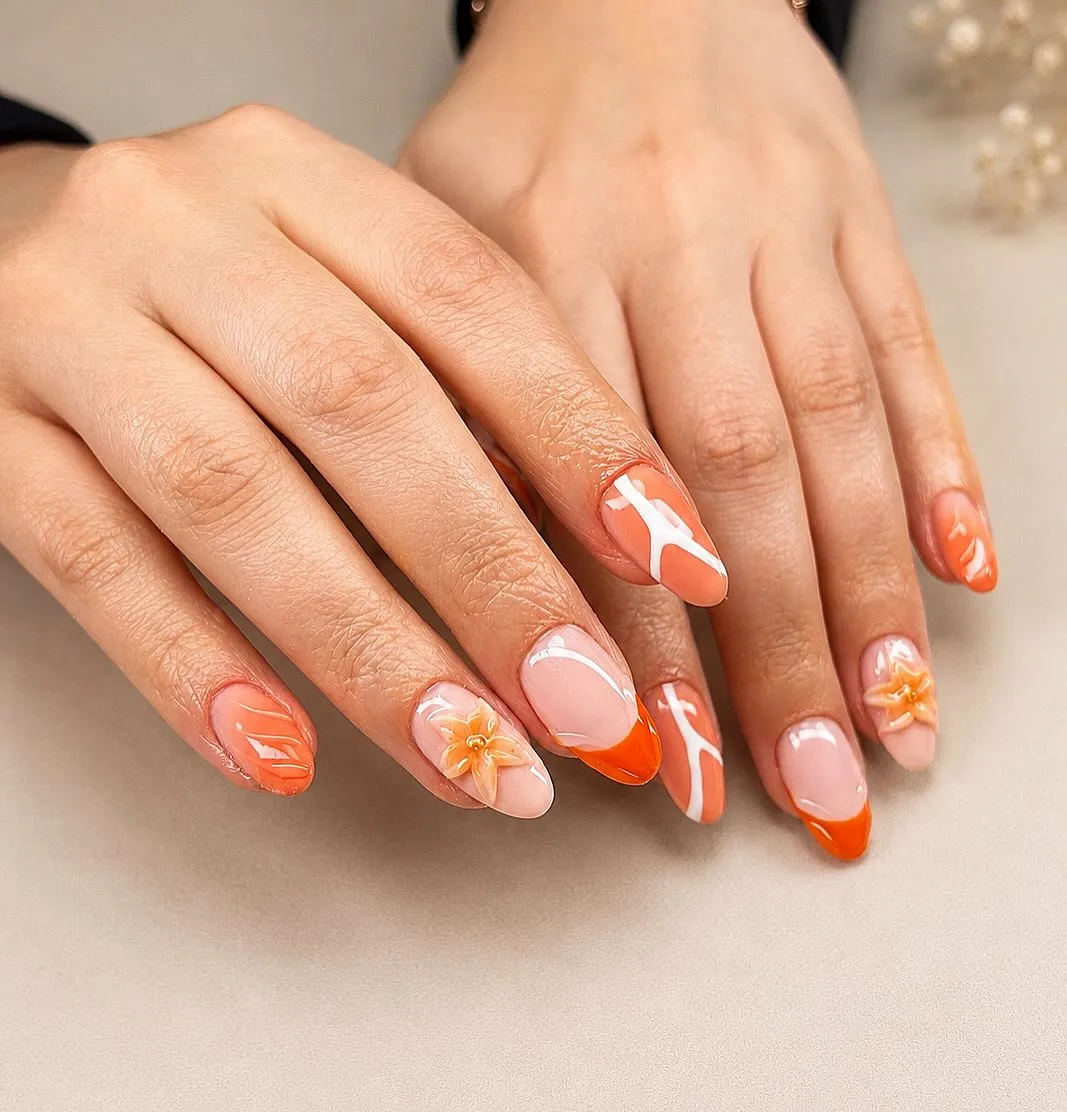 Orange French tips with white swirls and 3D flowers