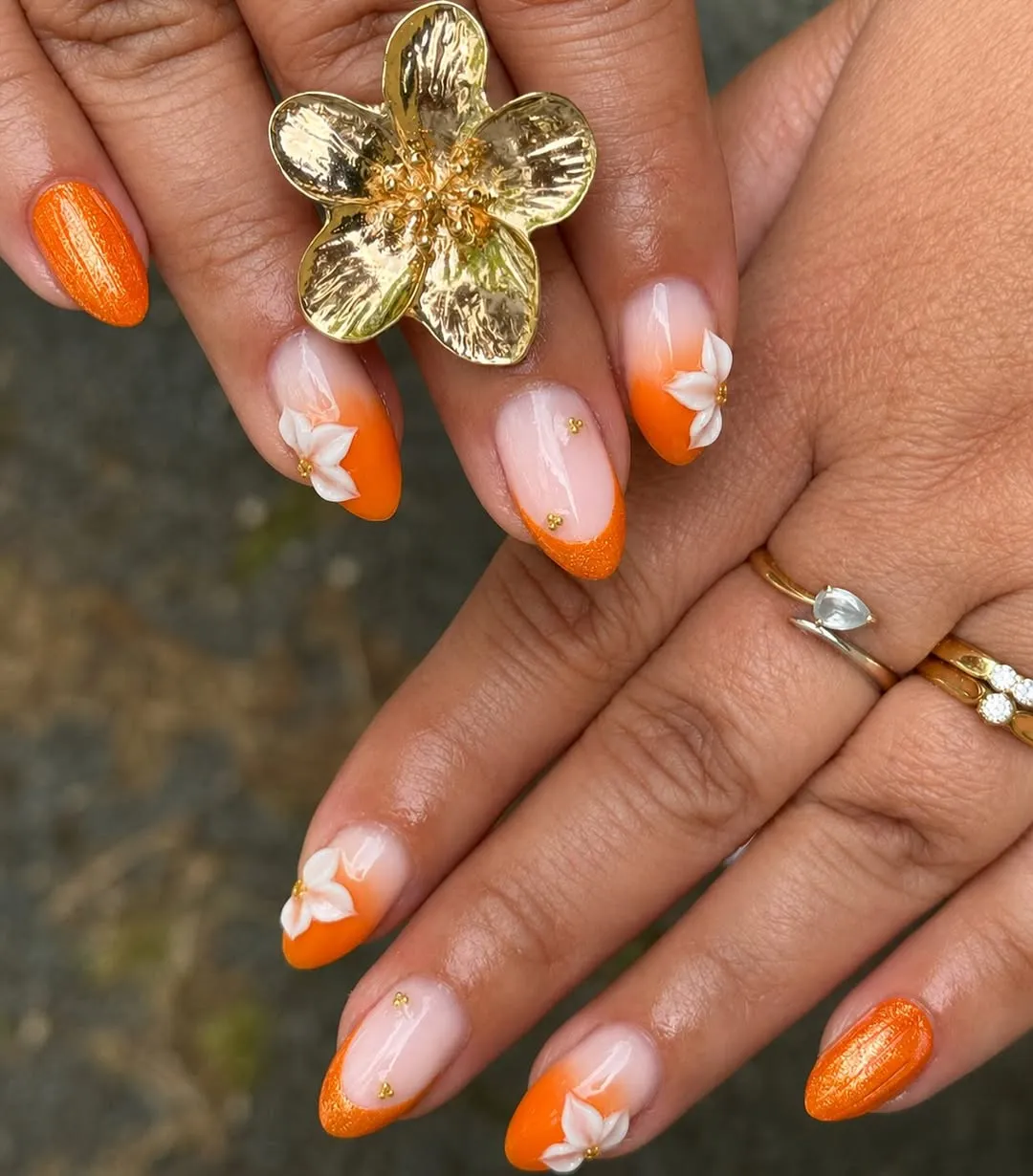 Orange ombre tips with white 3D flowers and shimmery orange accent nails