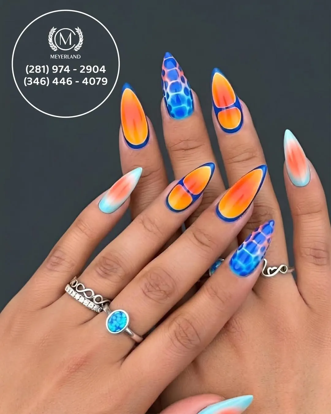 Orange ombre with dark blue outlines and blue patterned accent nails