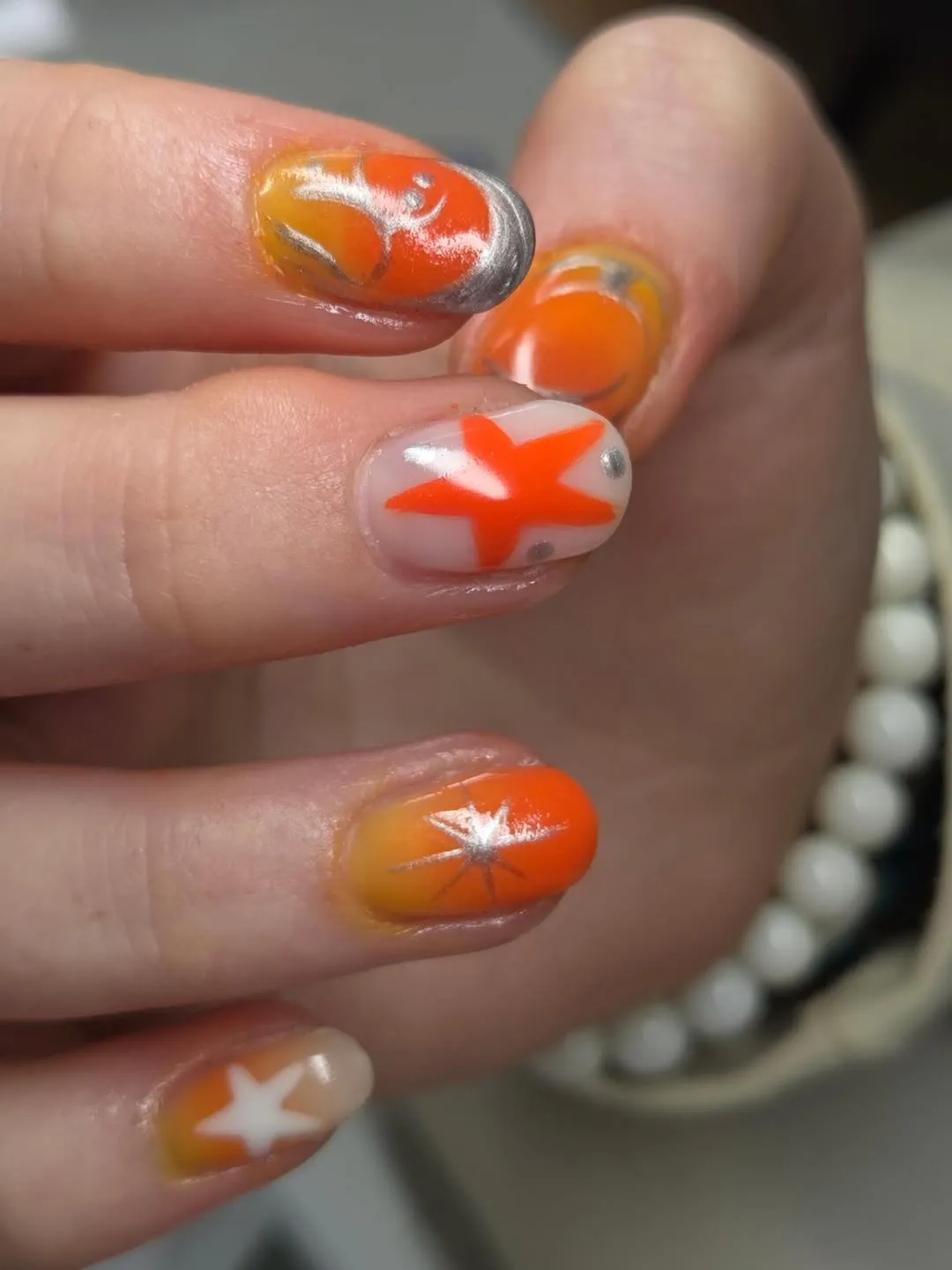Short orange ombre with star motifs and silver accents