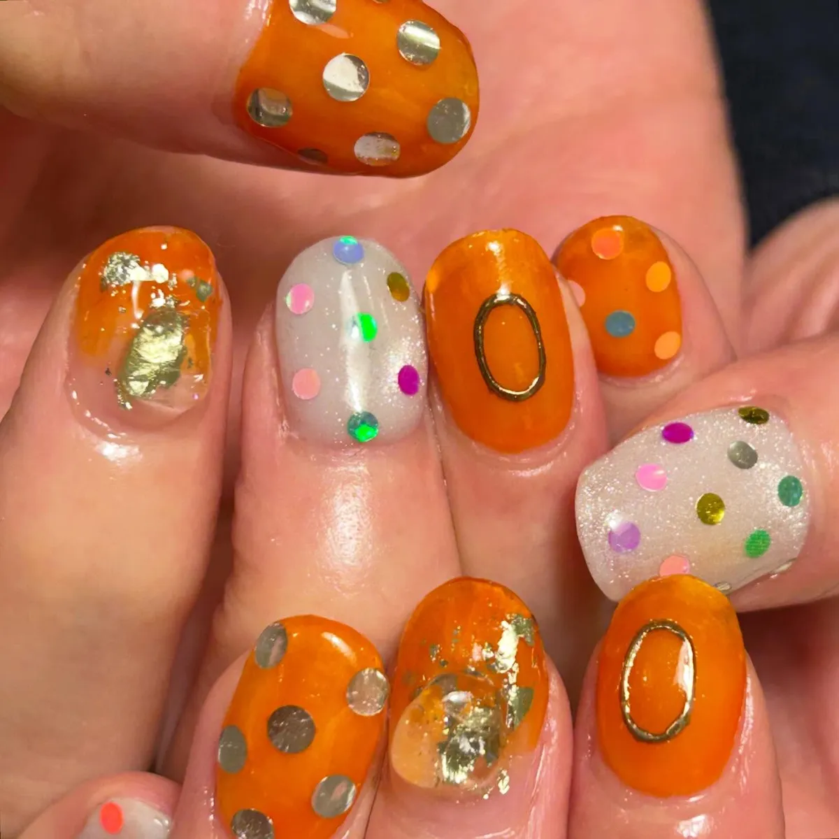 Orange polka dots with metallic circles and confetti accents