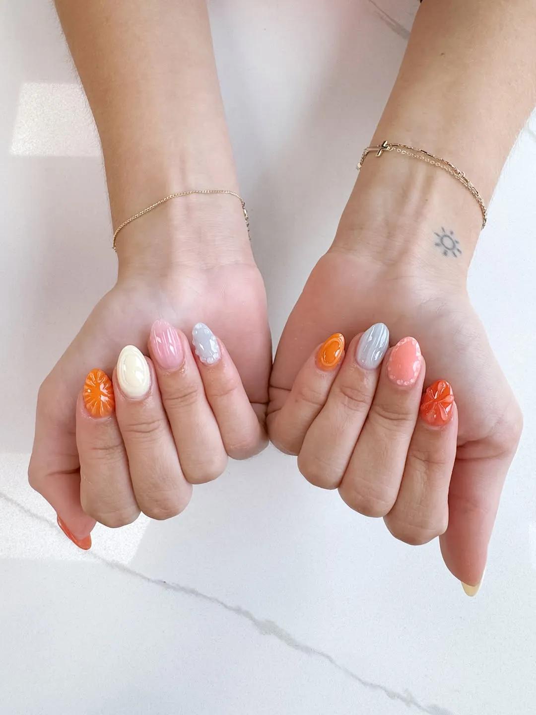 Multi-color pastel set with citrus-slice accents and textured pink nail