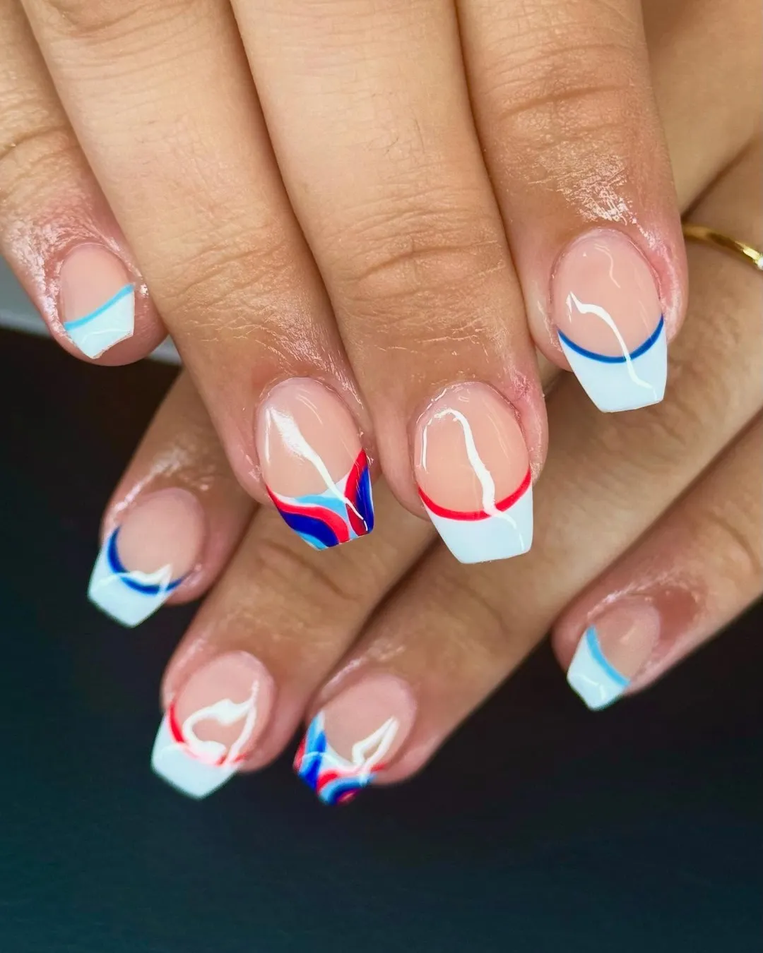 Square French tips with thin red/blue curved line accents