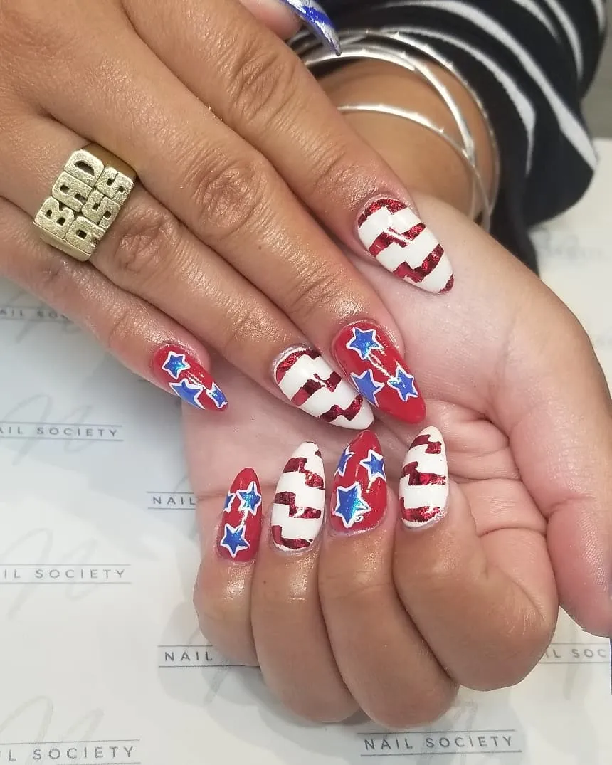 Almond nails with bold outlined stars and wavy stripe accents