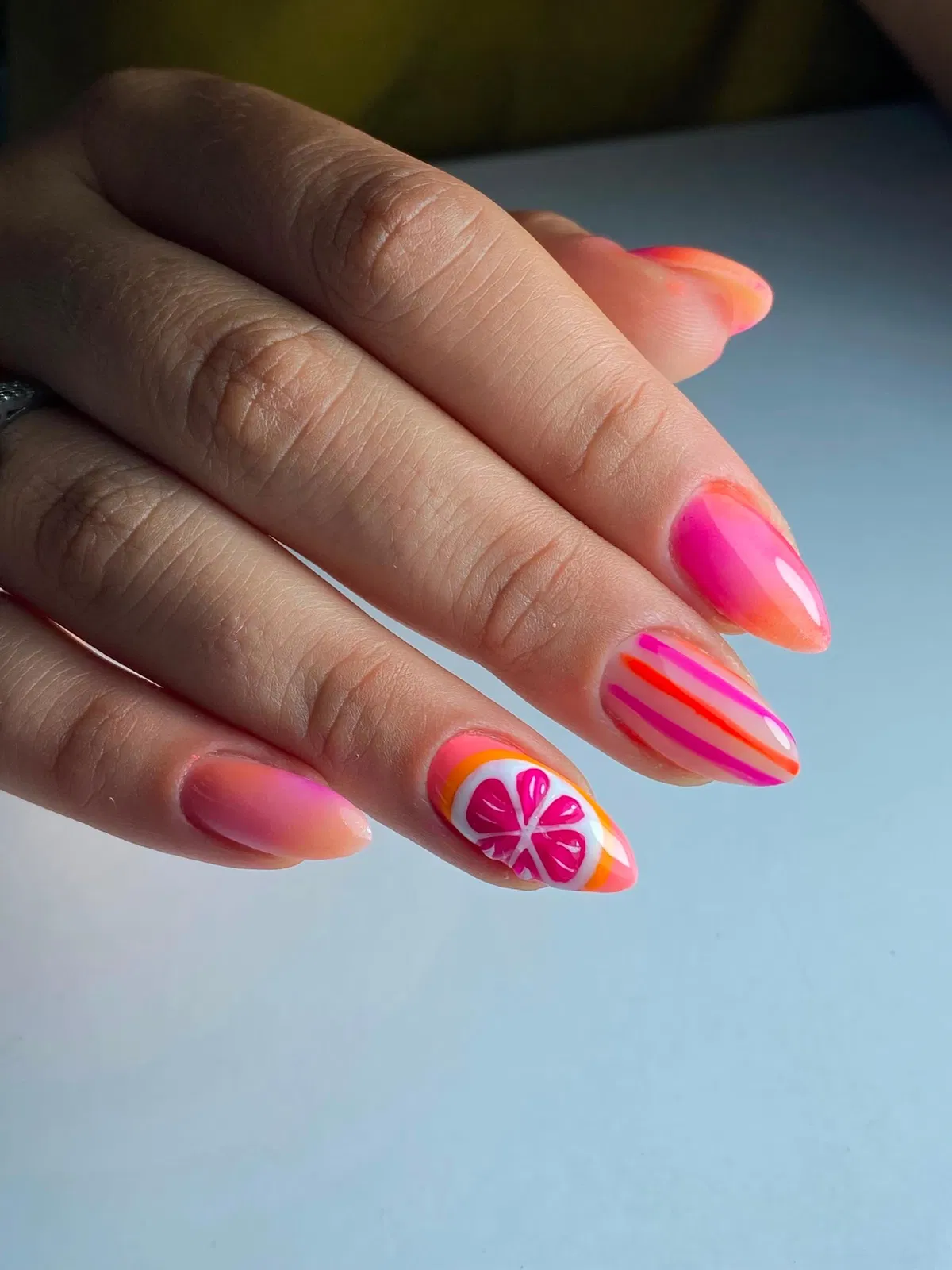 Pink-orange ombrΓ© with striped and citrus-slice accent nails