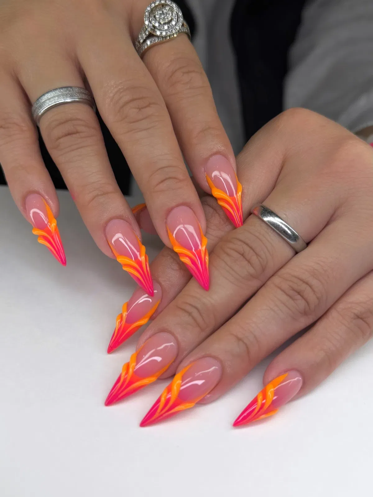 Neon flame-line stiletto nails in pink and orange
