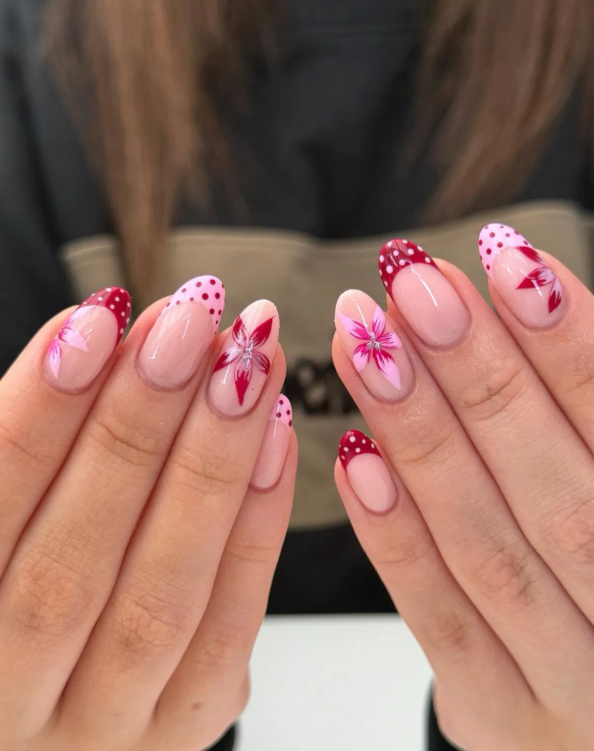 Deep red polka-dot French tips with floral accents