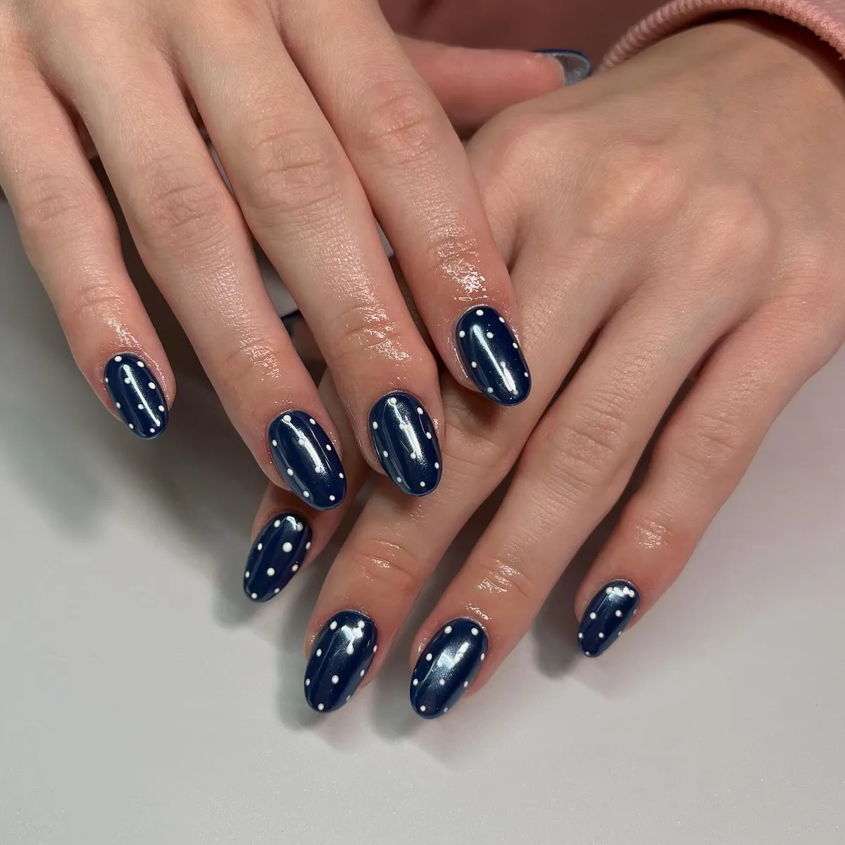 Navy glossy nails with small white polka dots