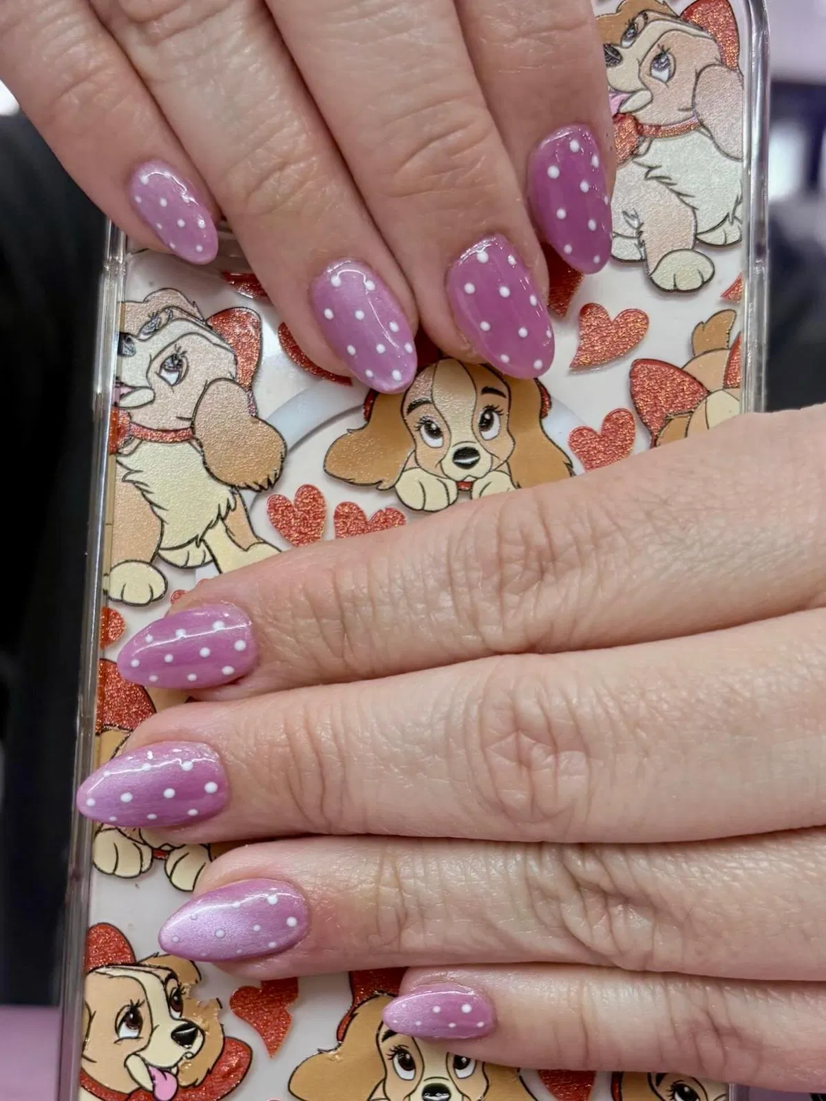 Lavender polka-dot nails with illustrated phone-case backdrop