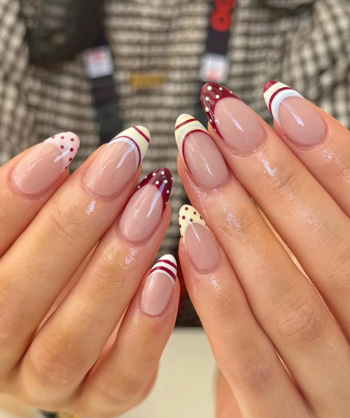 Burgundy-and-cream striped French tips with dotted accents