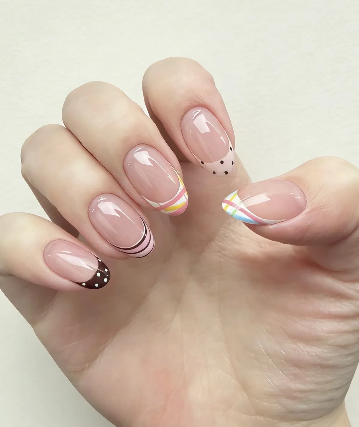 Mixed French tips: polka dots, pastel stripes, and minimal dots