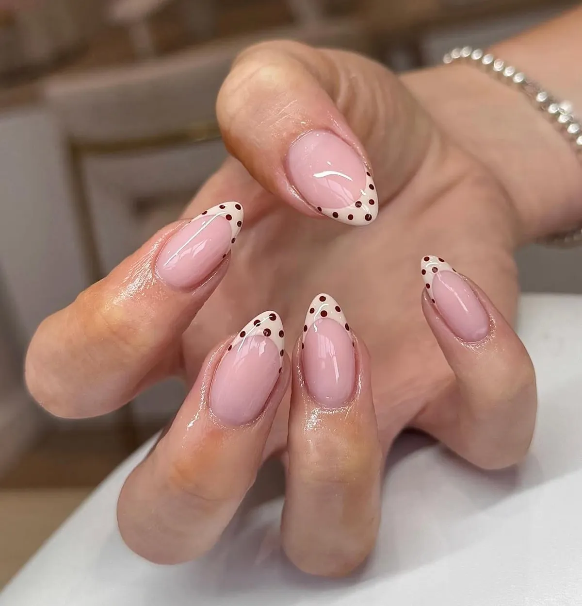 Soft pink base with brown polka-dot French tips