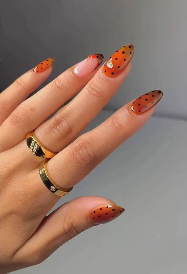 Orange almond nails with black polka dots