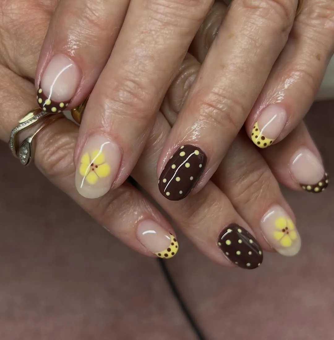 Short nude nails with dotted tips and yellow flowers