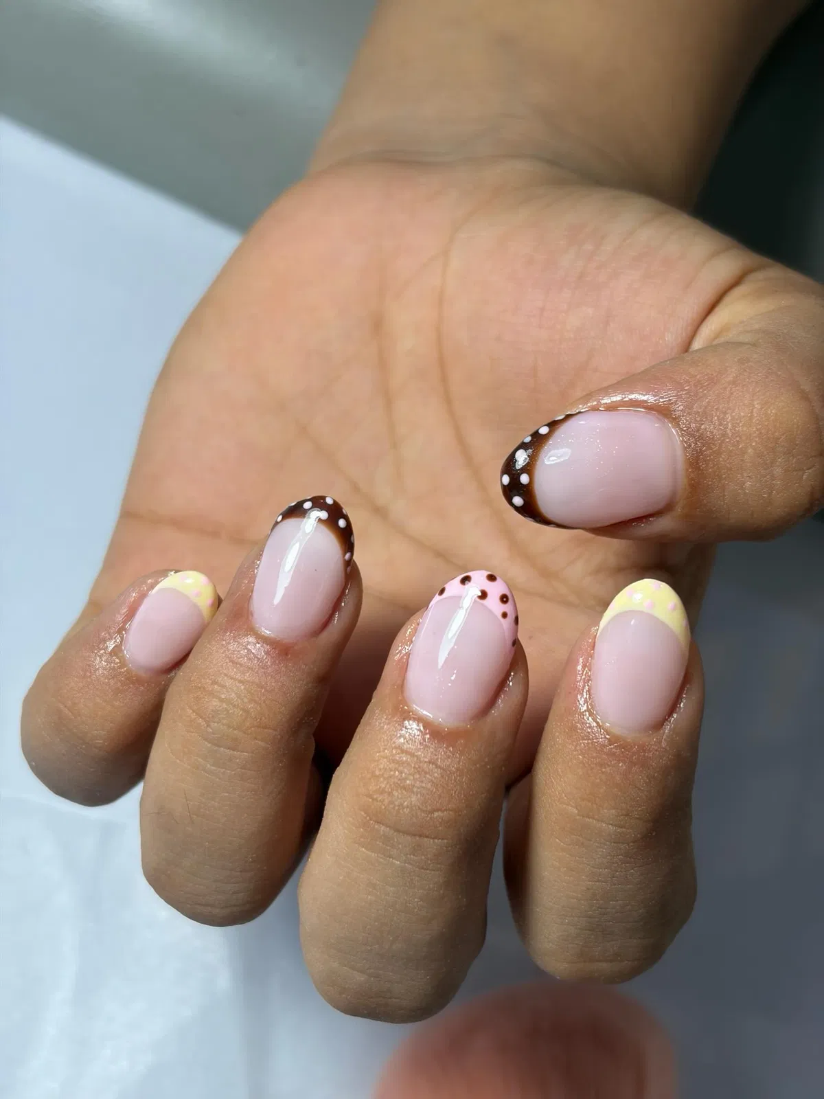 Short pink nails with mixed polka-dot French tips