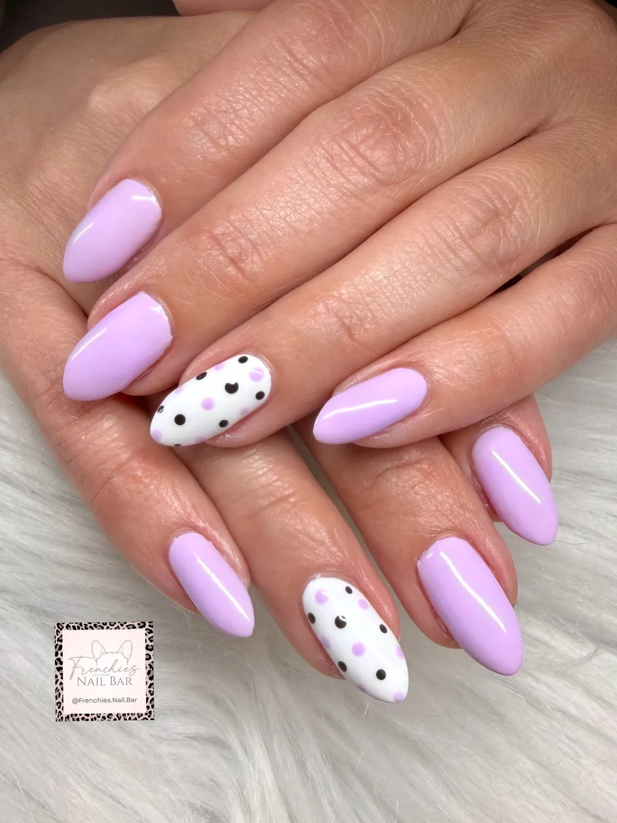 Light lavender nails with white-and-black polka-dot accents