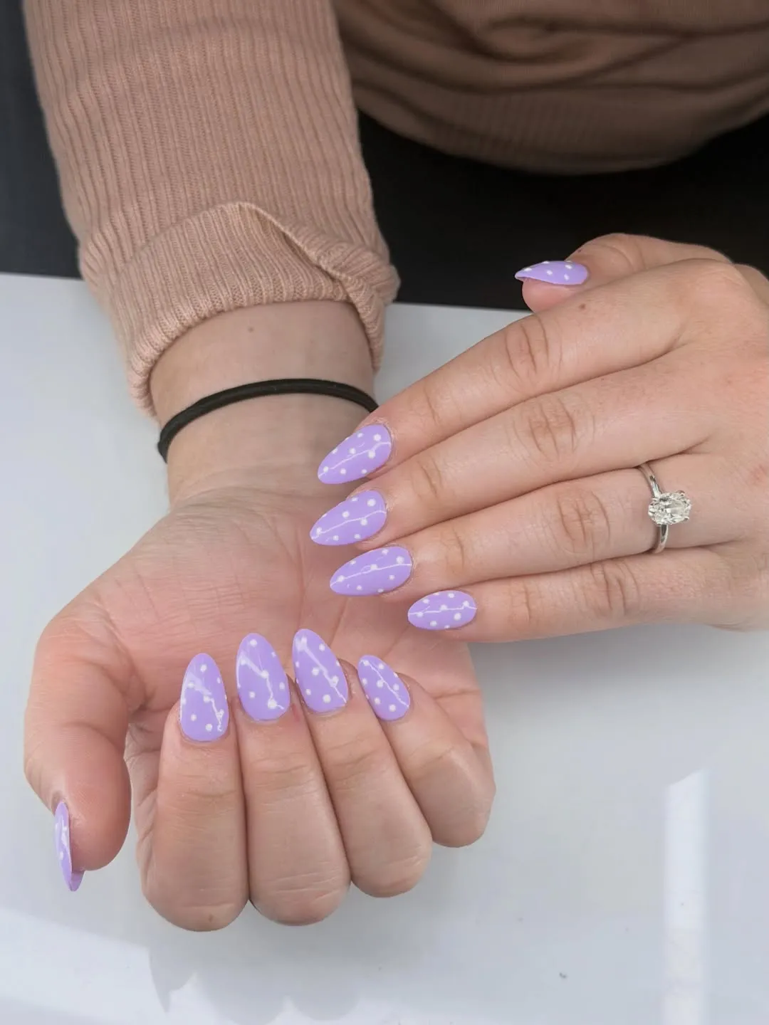 Lavender nails with white polka-dot rows and wavy line accents