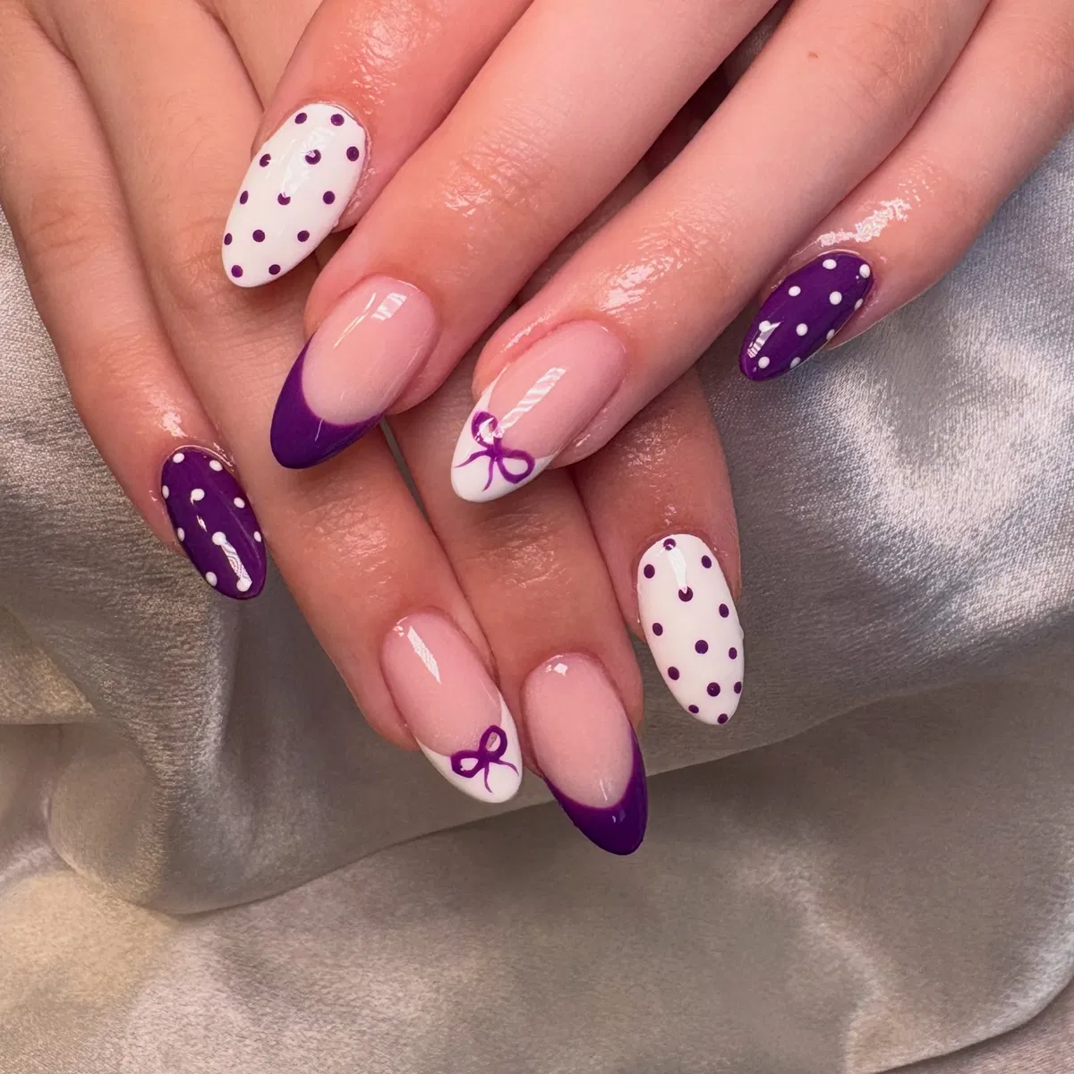 Deep purple and white polka dots with French tips and bow accents