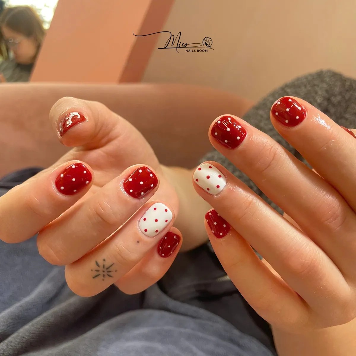 Classic red nails with white polka dots and white accent nails