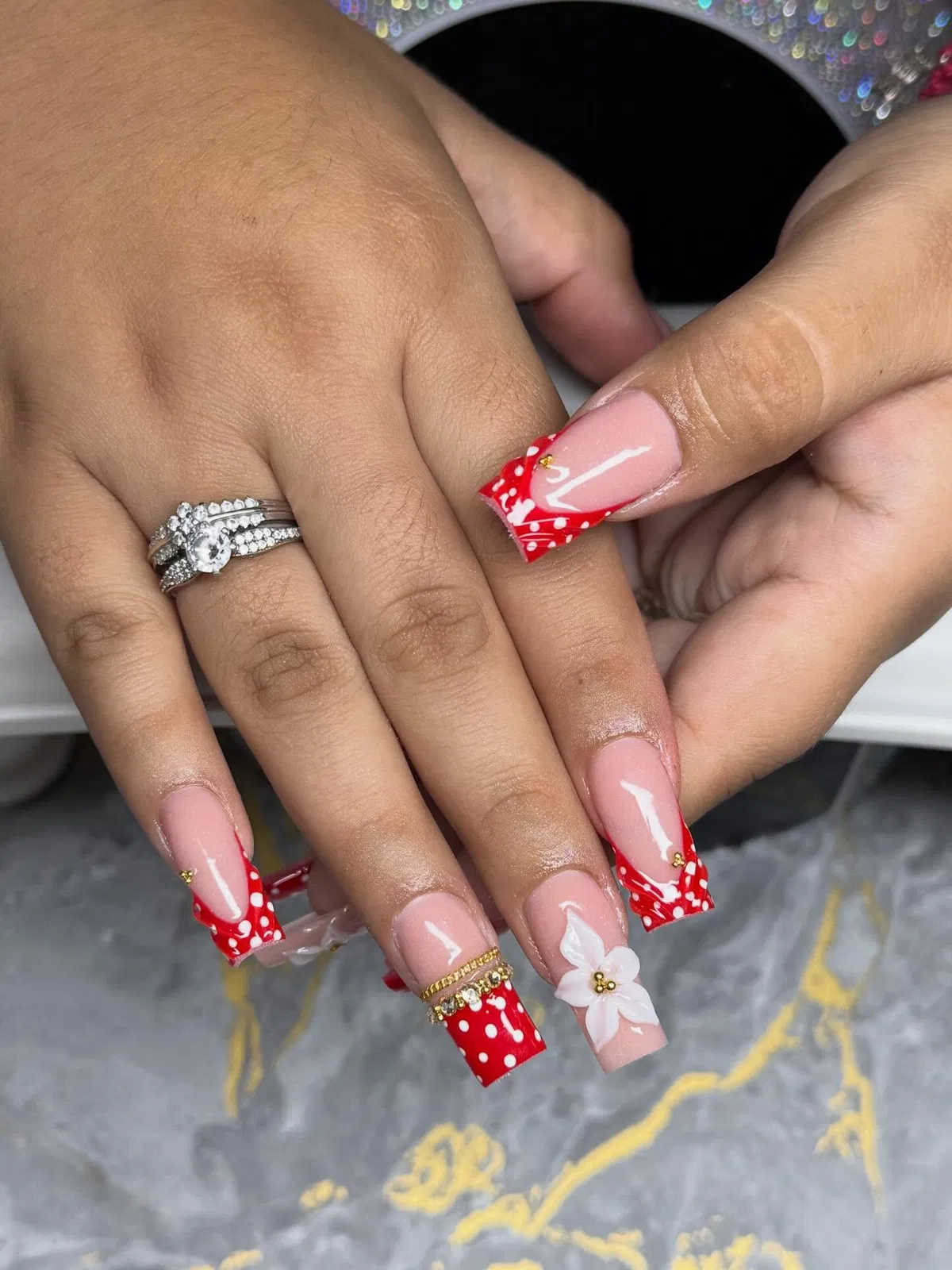 Long square red polka-dot French tips with raised flower accents