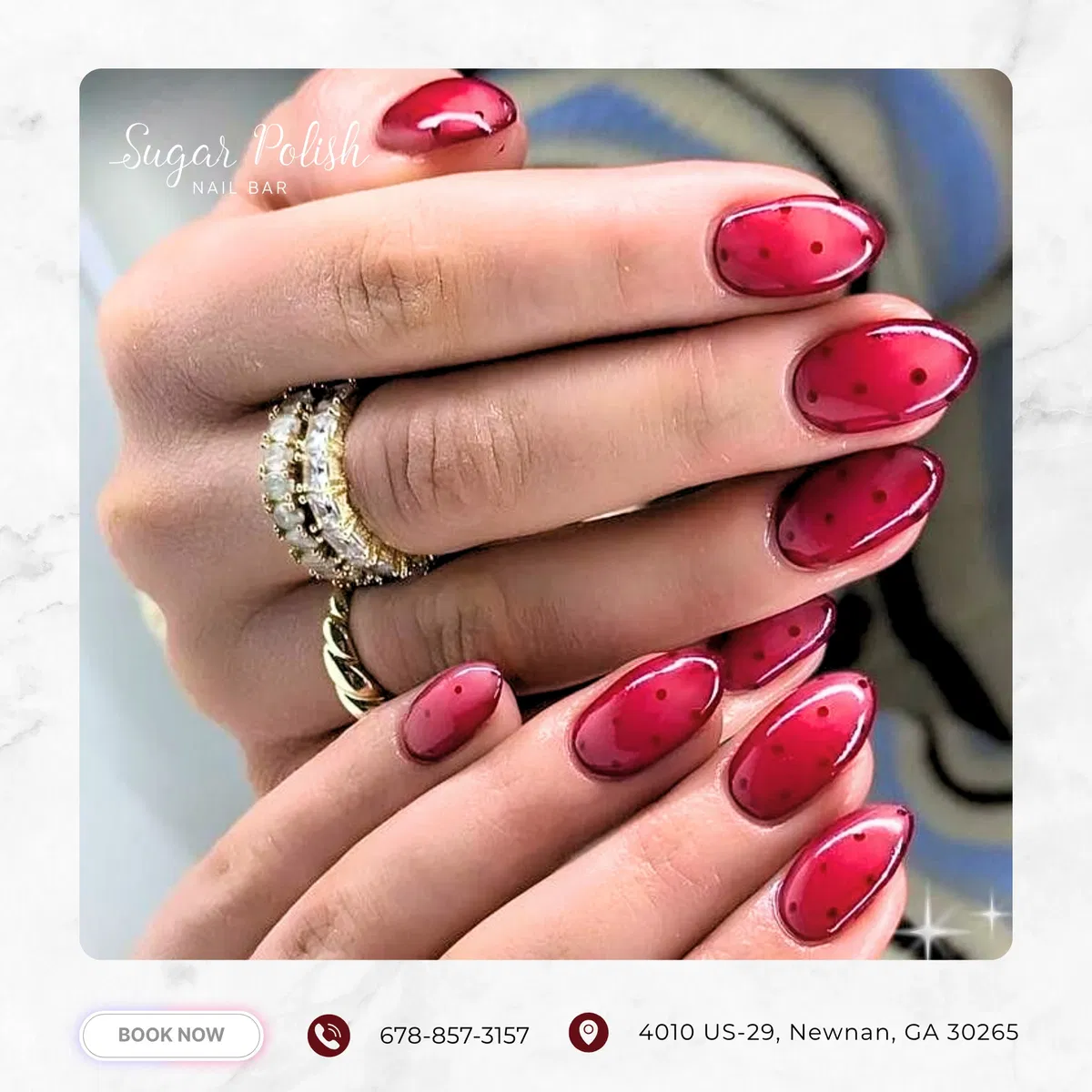 Translucent deep pink-red nails with darker spot pattern