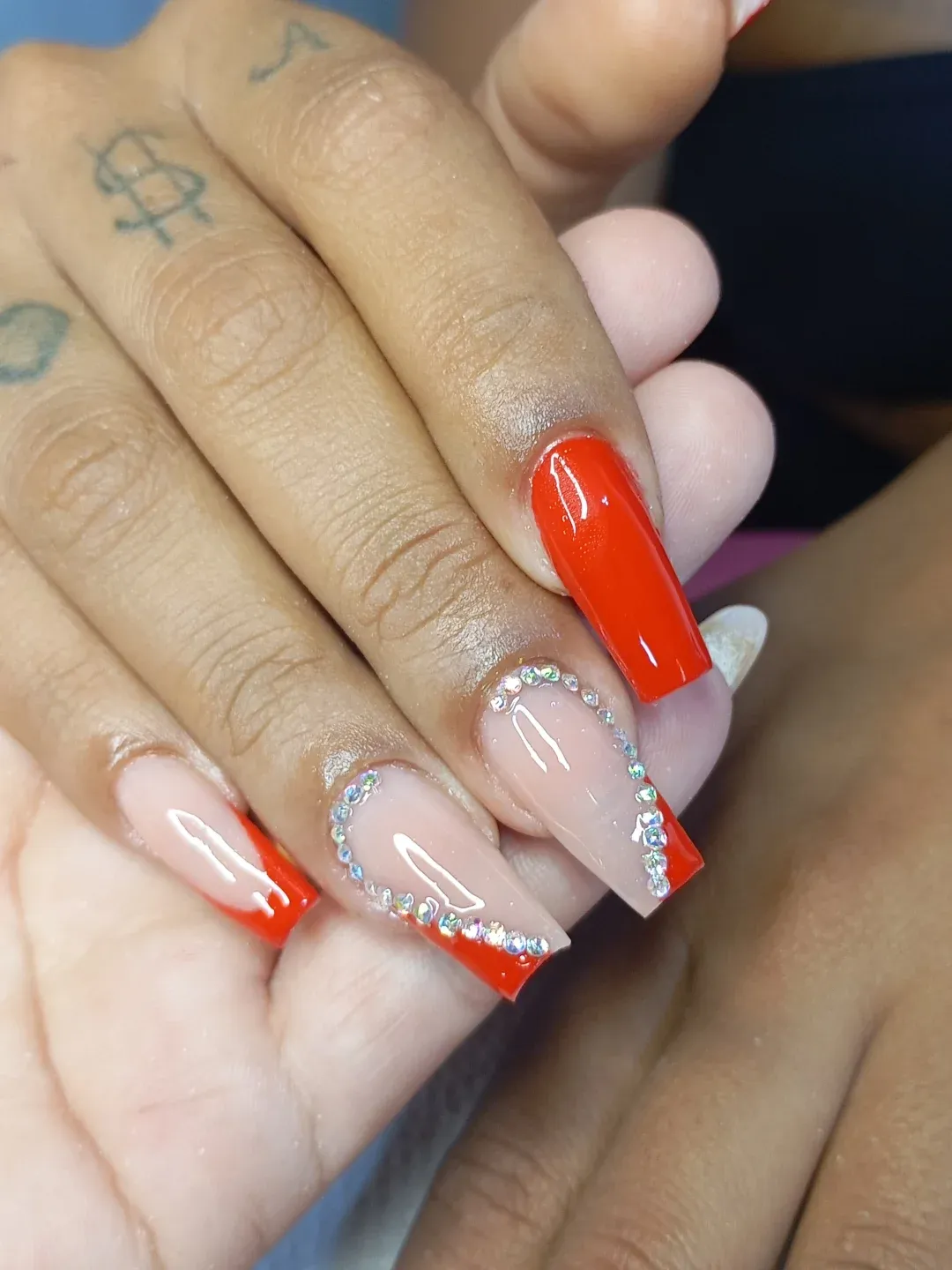 Orange-red tips with rhinestone-outlined accent nails