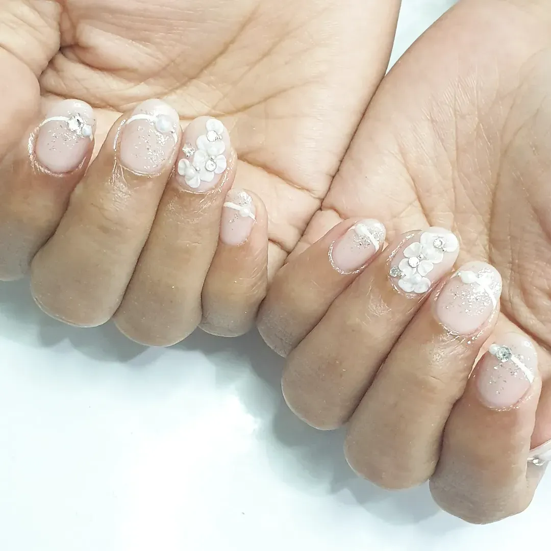 Nude-pink short nails with white edges and floral clusters