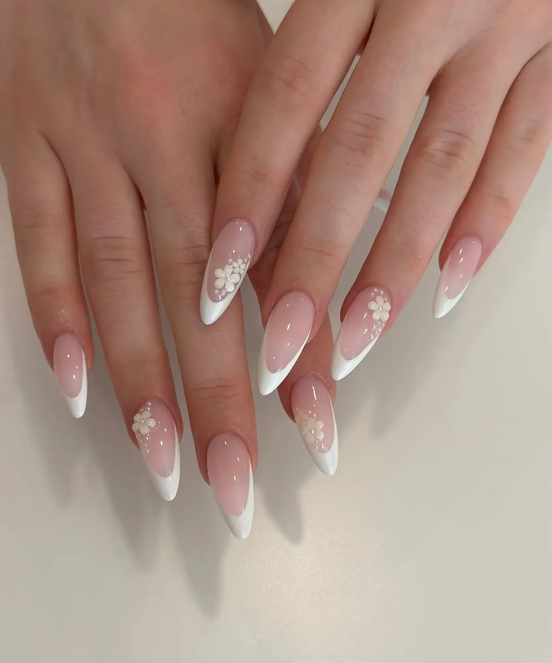 Pointed French tips with small 3D floral accents