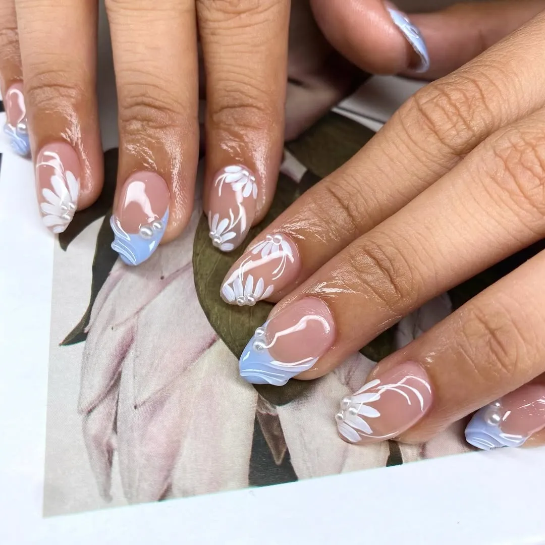 Nude short nails with light blue tips and white florals