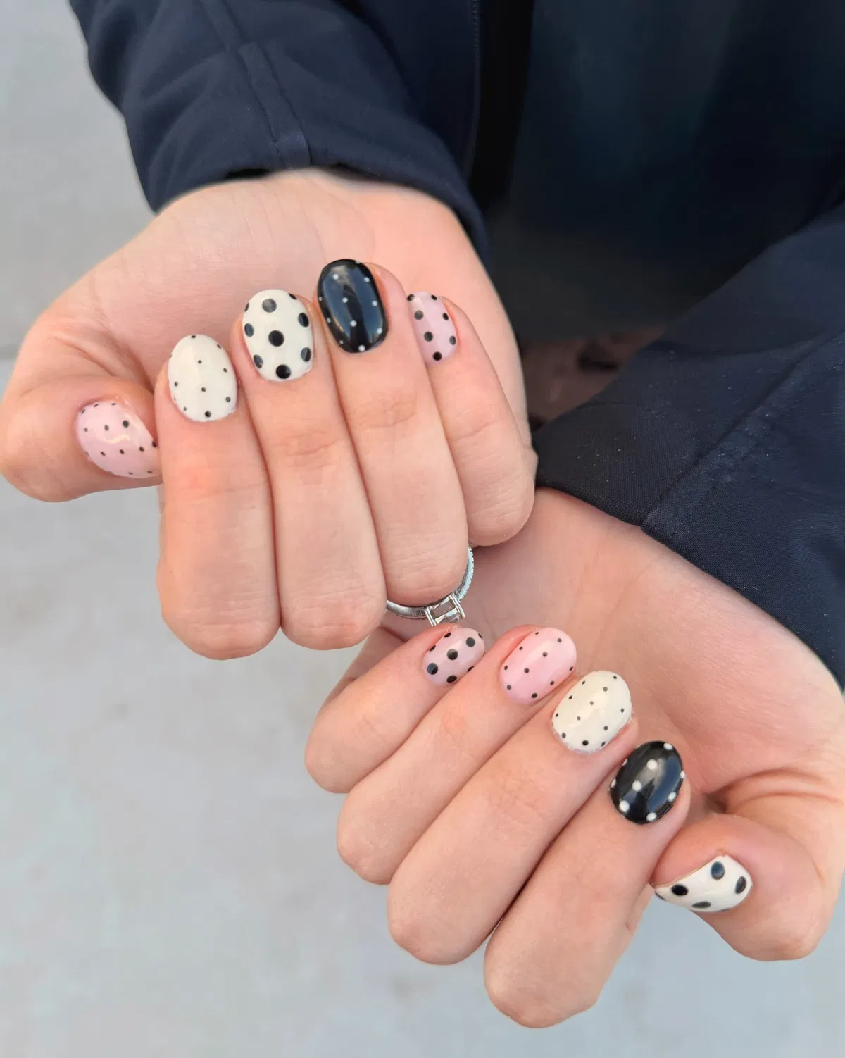 Soft pink and off-white polka dots with a black accent nail