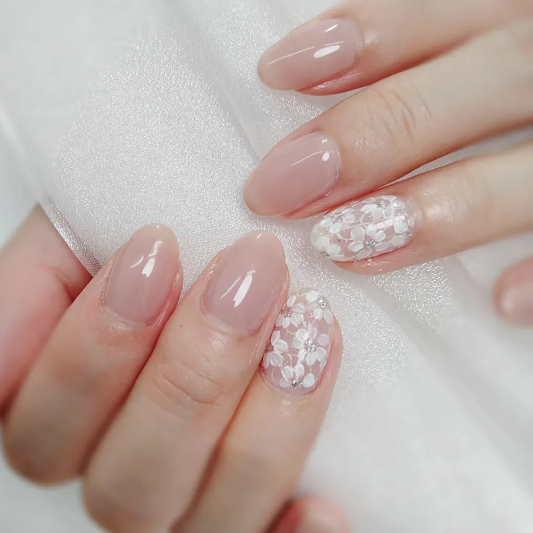 Sheer nude-pink with white floral accent nails